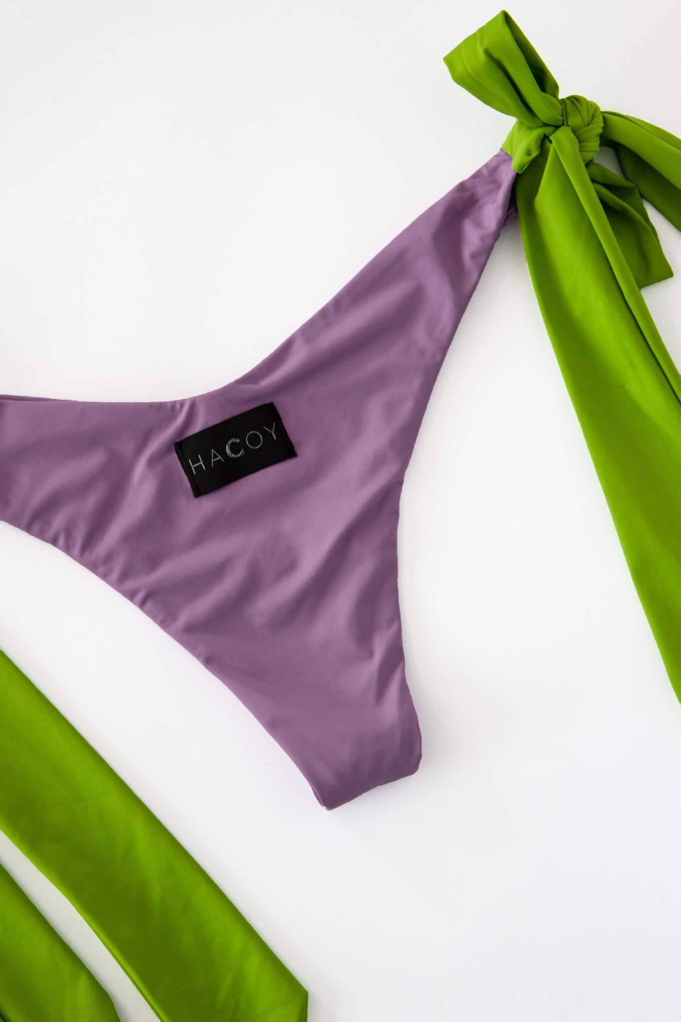 Dual Bikini in purple with green ties, featuring adjustable hardware-tipped sides for a customized fit.