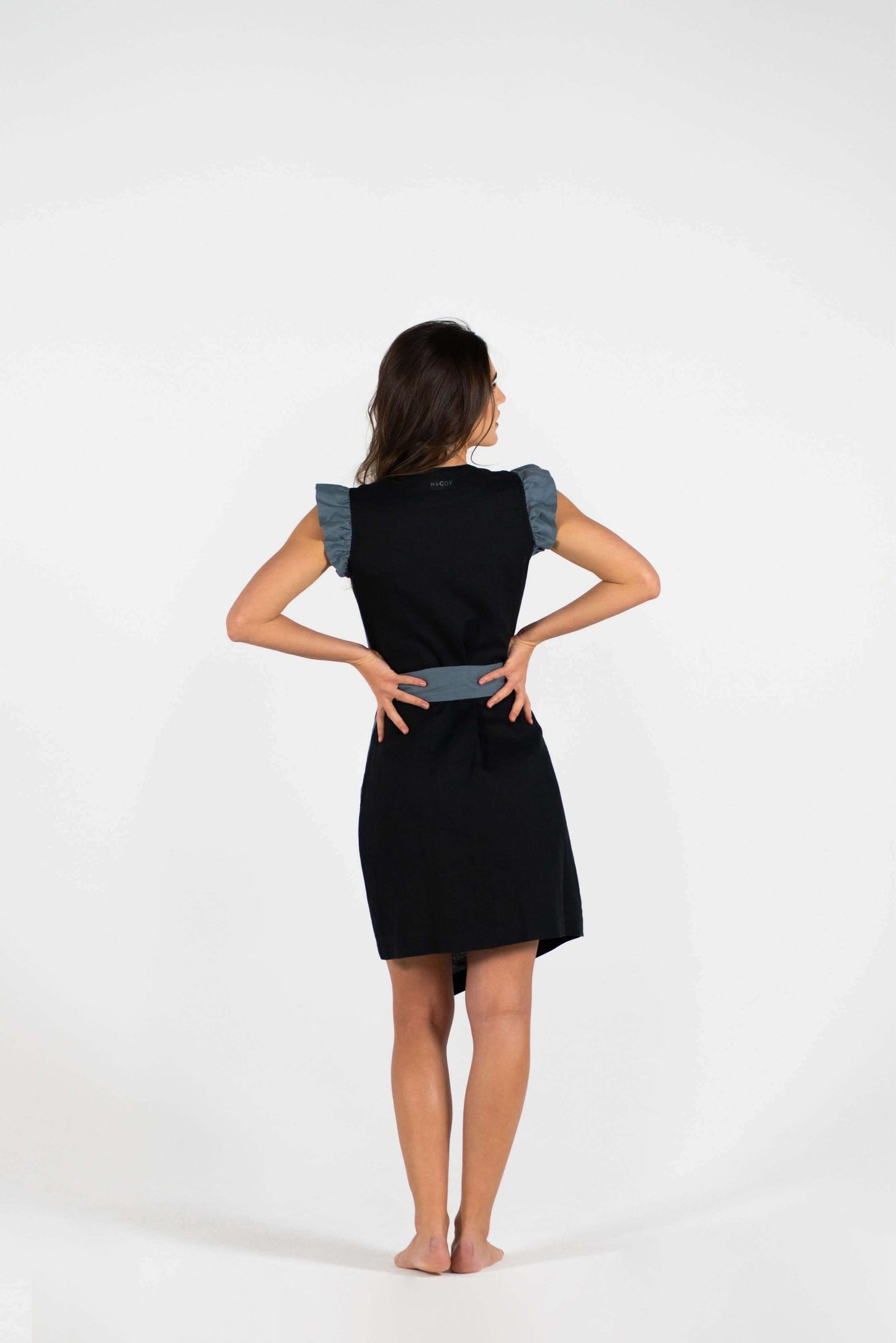 Model showcasing the back of the Linen Dual Dress, featuring stylish ruffled sleeves and a flattering wrap design.