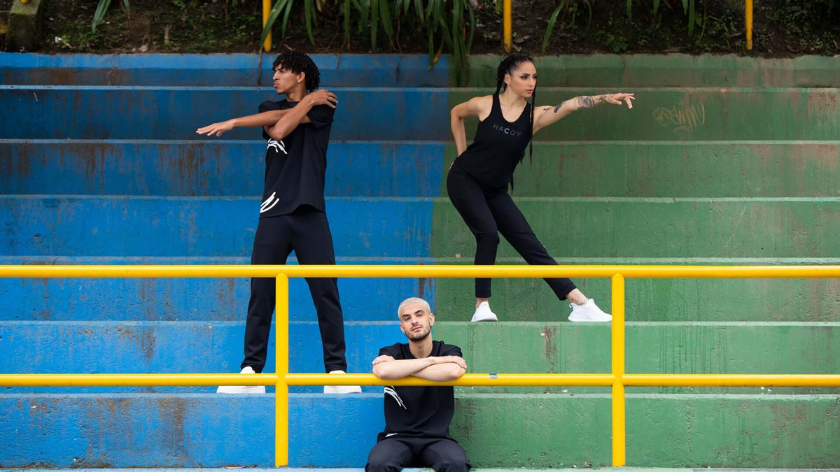 Three dancers in black outfits showcasing dynamic poses on colorful steps, emphasizing movement and style.