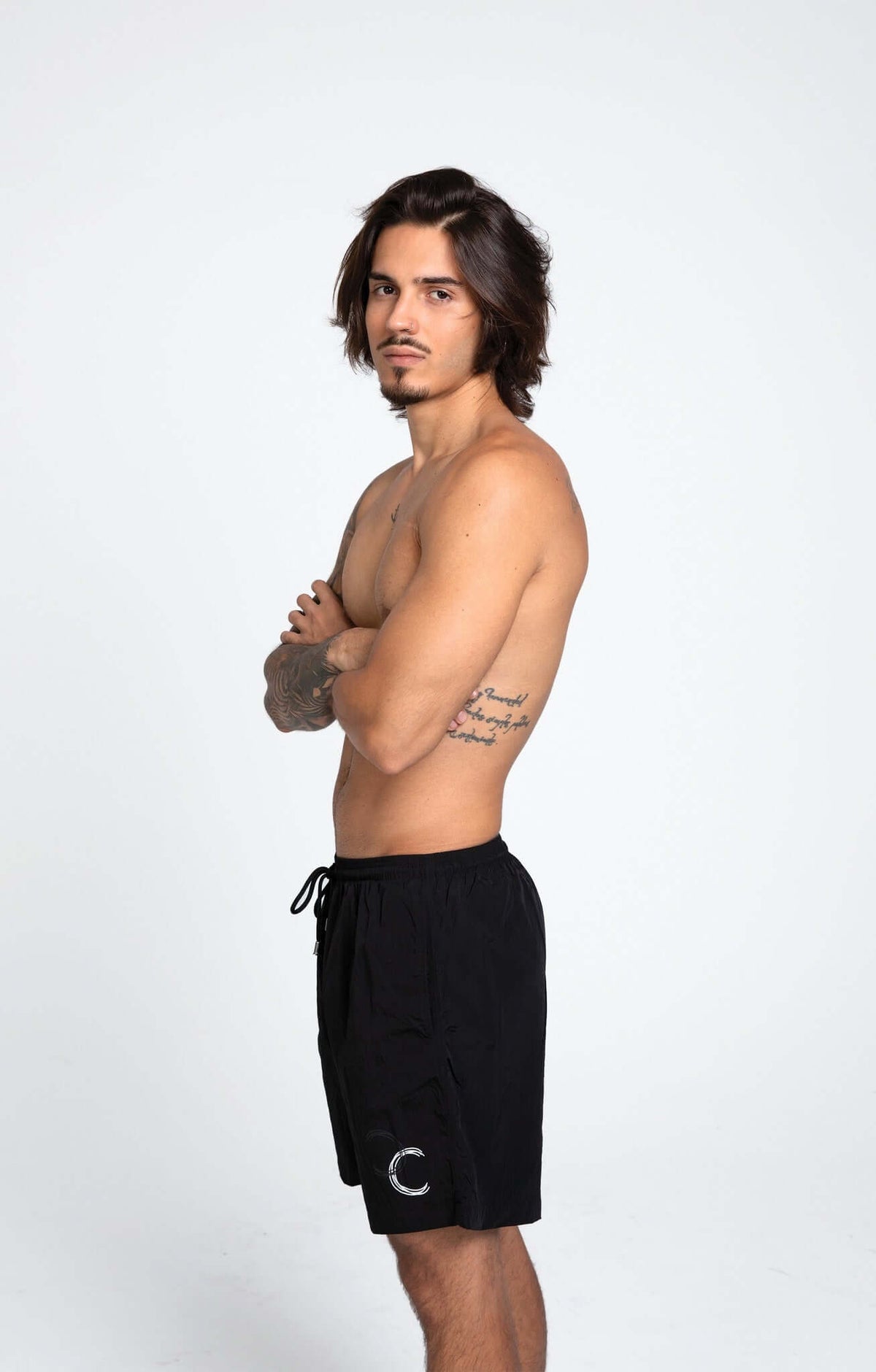 Model showcasing black swim shorts with HACOY logo, emphasizing style and comfort in swimwear.