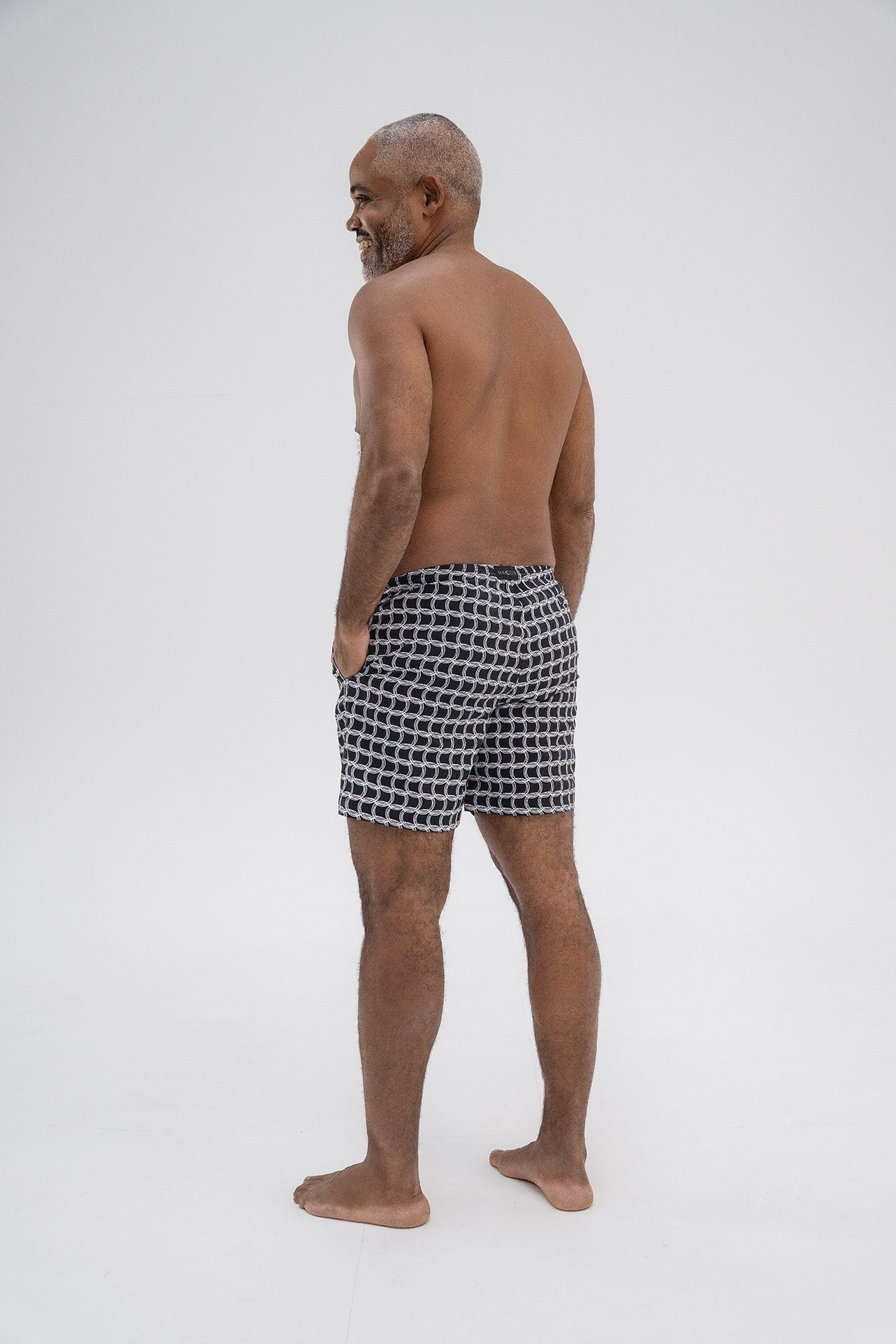 Back view of HACOY Monogram Swim Shorts showing rear pocket and tailored fit