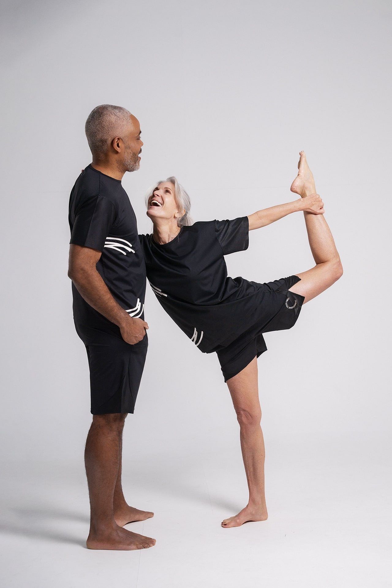 Two models male and female wearing HACOY Unisex Sports Shorts together in studio